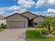 Tan one-story house with two-car garage and landscaped yard on a sunny day at 4505 Back Nine Dr, Winter Haven, FL 33884