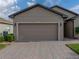 Two car garage with tan doors and paved driveway at 4505 Back Nine Dr, Winter Haven, FL 33884