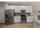 Kitchen boasts stainless steel appliances and white cabinetry at 4505 Back Nine Dr, Winter Haven, FL 33884