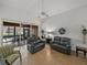 Relaxing living room with gray sofas and a view of the screened lanai and dining area at 4505 Back Nine Dr, Winter Haven, FL 33884