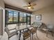 Bright screened patio with table, chairs, and wicker sofa, overlooking a backyard at 4505 Back Nine Dr, Winter Haven, FL 33884