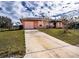 Damaged house with pink garage door and overgrown yard at 517 Cipres Cir, Winter Haven, FL 33880