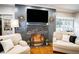 Cozy living room with a fireplace, hardwood floors, and comfortable seating at 524 Arneson Ave, Auburndale, FL 33823