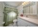 Bathroom with a tub/shower, vanity, and floral-patterned wallpaper at 615 E Haines Blvd, Lake Alfred, FL 33850