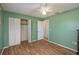 Bedroom with wood-look floors, large closet, and access to hallway at 615 E Haines Blvd, Lake Alfred, FL 33850