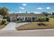 Tan house with green roof, landscaping, and driveway at 615 E Haines Blvd, Lake Alfred, FL 33850
