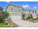 Two-story house with green exterior, white garage door, and landscaping at 723 Chinoy Rd, Davenport, FL 33837