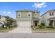 Two-story house with green exterior, white garage door, and landscaping at 723 Chinoy Rd, Davenport, FL 33837