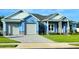 Beautiful two-story home with light blue exterior, gray stone accents, and a large driveway at 780 Waterfern Trail Dr, Auburndale, FL 33823
