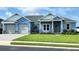 Charming light blue two-story house with gray roof and landscaping at 780 Waterfern Trail Dr, Auburndale, FL 33823