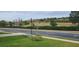 Quiet street view with lush landscaping and pond at 780 Waterfern Trail Dr, Auburndale, FL 33823