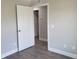 A bedroom featuring neutral walls, modern base trim, and gray wood-look flooring with a white door at 809 Lincoln St, Babson Park, FL 33827