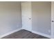 A bedroom featuring neutral walls, modern base trim, and gray wood-look flooring with a white door at 809 Lincoln St, Babson Park, FL 33827