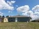 Back view of a gray home with blue skies and a modest backyard at 809 Lincoln St, Babson Park, FL 33827