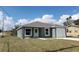 Gray home with a brown roof and a white garage door with fresh lawn and landscaping at 809 Lincoln St, Babson Park, FL 33827