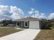 Front exterior of a gray home with blue skies and a white driveway and garage door at 809 Lincoln St, Babson Park, FL 33827