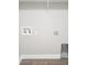 A laundry room featuring neutral walls, modern base trim, and gray wood-look flooring and wire shelving at 809 Lincoln St, Babson Park, FL 33827