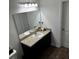 Double vanity bathroom with dark brown cabinets and a large mirror at 932 Grandin St, Davenport, FL 33837