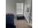 Well-lit bedroom featuring a twin bed, window blinds, and storage ottoman at 932 Grandin St, Davenport, FL 33837