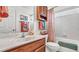 Clean bathroom with a single sink vanity, bathtub, and coral-themed decor at 1153 Legatto Loop, Dundee, FL 33838