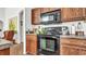Kitchen with dark wood cabinets and black appliances at 1153 Legatto Loop, Dundee, FL 33838