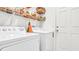 Convenient laundry room with washer, dryer, and overhead shelving at 1153 Legatto Loop, Dundee, FL 33838