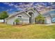 Gray house with landscaped yard, palm trees, and a two-car garage at 1932 Southern Dunes Blvd, Haines City, FL 33844