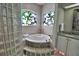 Bathroom with corner soaking tub, double vanity, and stained glass windows at 2119 Kirkland Lake Dr, Auburndale, FL 33823