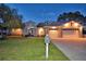 Two-story house with a three-car garage and manicured lawn at dusk at 2119 Kirkland Lake Dr, Auburndale, FL 33823
