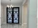 Well-lit entryway with stylish double doors and marble-look tile flooring at 2510 Lakefront Dr, Lake Wales, FL 33898