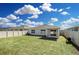 Well-maintained backyard featuring a lush lawn, white vinyl fence, and a covered lanai at 264 Spirit Landings Cir, Winter Haven, FL 33880