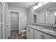 Bright bathroom featuring a double vanity with granite countertop and a walk-in closet at 264 Spirit Landings Cir, Winter Haven, FL 33880