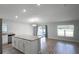 Kitchen island overlooks the hardwood floor living room with large glass sliding doors at 264 Spirit Landings Cir, Winter Haven, FL 33880