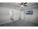 Carpeted bedroom features an adjoining bathroom, a ceiling fan, and a mounted TV at 264 Spirit Landings Cir, Winter Haven, FL 33880