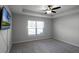 Carpeted bedroom features a ceiling fan, bright window, and a mounted TV at 264 Spirit Landings Cir, Winter Haven, FL 33880