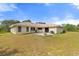 Rear exterior with a patio area, perfect for grilling, and seating with a spacious grassy area at 2772 Indian Pipes Trl, Frostproof, FL 33843
