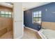 Charming bathroom showcasing blue accent wall, and shower with corner bench seating at 2772 Indian Pipes Trl, Frostproof, FL 33843