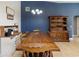 Spacious dining area with wooden furniture set against a blue accent wall, adjacent to the kitchen at 2772 Indian Pipes Trl, Frostproof, FL 33843