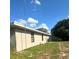 Exterior view of home featuring grass lawn, beige siding, and AC unit at 2772 Indian Pipes Trl, Frostproof, FL 33843