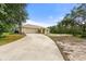 Home exterior, showcasing the driveway, 2-car garage, mature trees and drought-resistant landscaping at 2772 Indian Pipes Trl, Frostproof, FL 33843