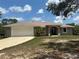 Charming single-story home featuring a two-car garage, a well-manicured lawn, and mature trees at 2772 Indian Pipes Trl, Frostproof, FL 33843