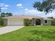 Charming single-story home featuring a well-manicured lawn and a two-car garage at 2772 Indian Pipes Trl, Frostproof, FL 33843