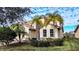 Tan two-story house with palm trees and landscaping at 3526 Valleyview Dr, Kissimmee, FL 34746