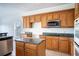 Kitchen boasts wood cabinets, granite counters, and stainless steel appliances at 3526 Valleyview Dr, Kissimmee, FL 34746