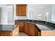 Kitchen with an L-shaped granite countertop and wood cabinets at 3526 Valleyview Dr, Kissimmee, FL 34746