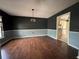 Formal dining room featuring hardwood floors, wainscoting, and access to an adjacent kitchen with white cabinets at 3710 Black Jack Ct, Lake Wales, FL 33898
