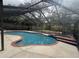 Large screened-in pool with spa, offering a view of the lush backyard with mature trees and a storage shed at 3710 Black Jack Ct, Lake Wales, FL 33898