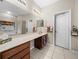 Double vanity bathroom with a large mirror and tile floors at 4195 Muirfield Loop, Lake Wales, FL 33859