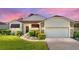Attractive single-story home with landscaped yard, paver driveway, and two-car garage at 4195 Muirfield Loop, Lake Wales, FL 33859