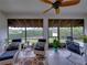Bright screened porch, wicker furniture, ceiling fan at 4195 Muirfield Loop, Lake Wales, FL 33859